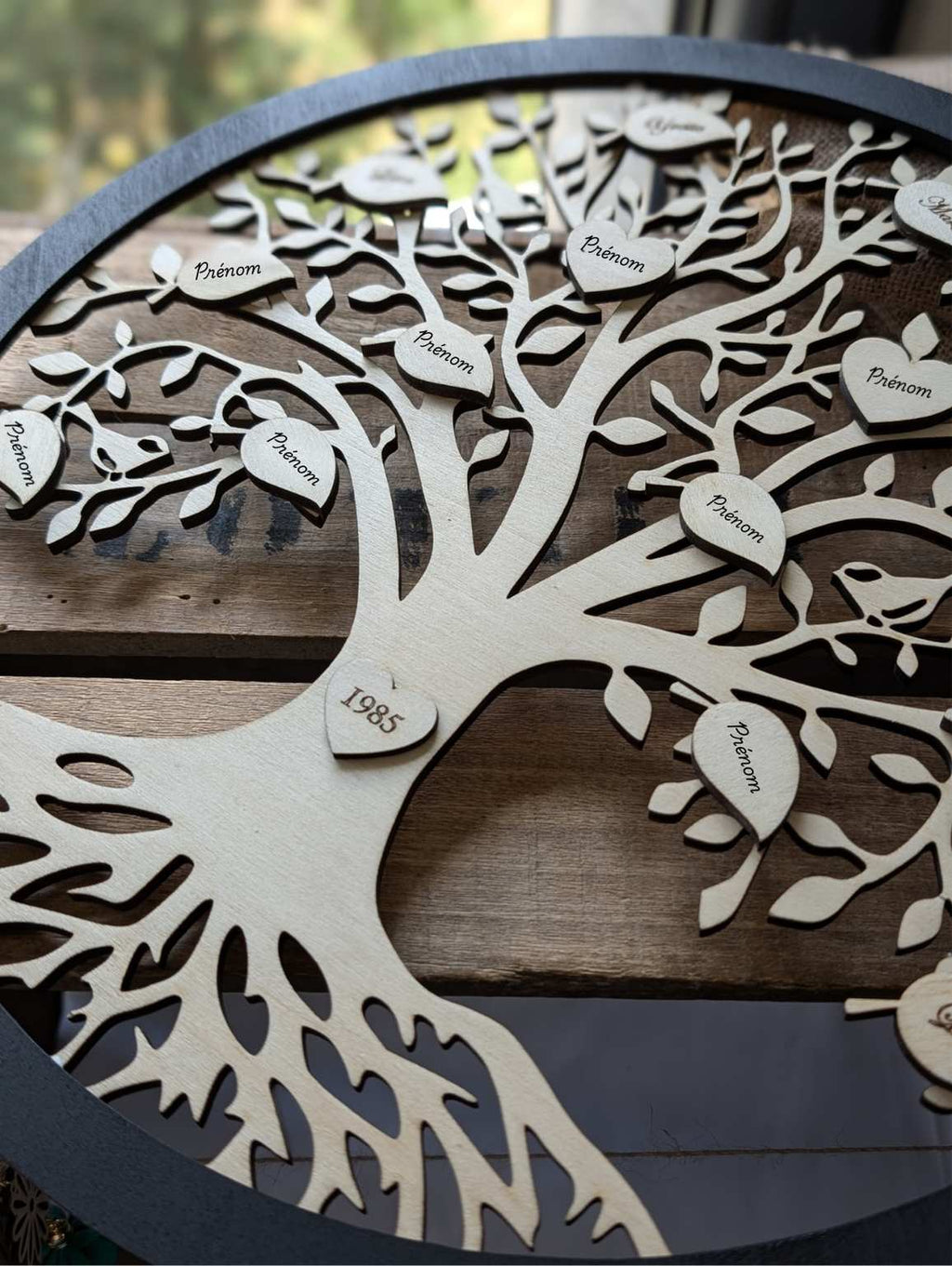 Détail arbre de vie en bois avec prénoms gravés au laser - contour noir et arbre naturel