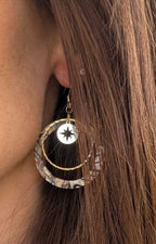 Boucles d'oreilles créoles acrylique zébré nacré et étoile dorée portées à l'oreille — Artesama