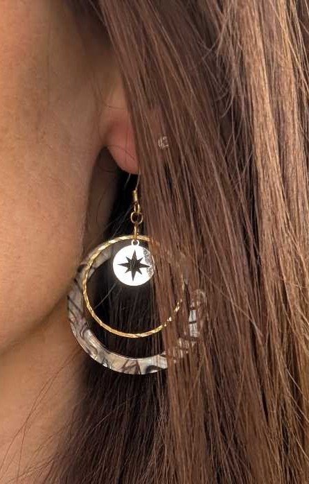 Boucles d'oreilles créoles acrylique zébré nacré et étoile dorée portées à l'oreille — Artesama
