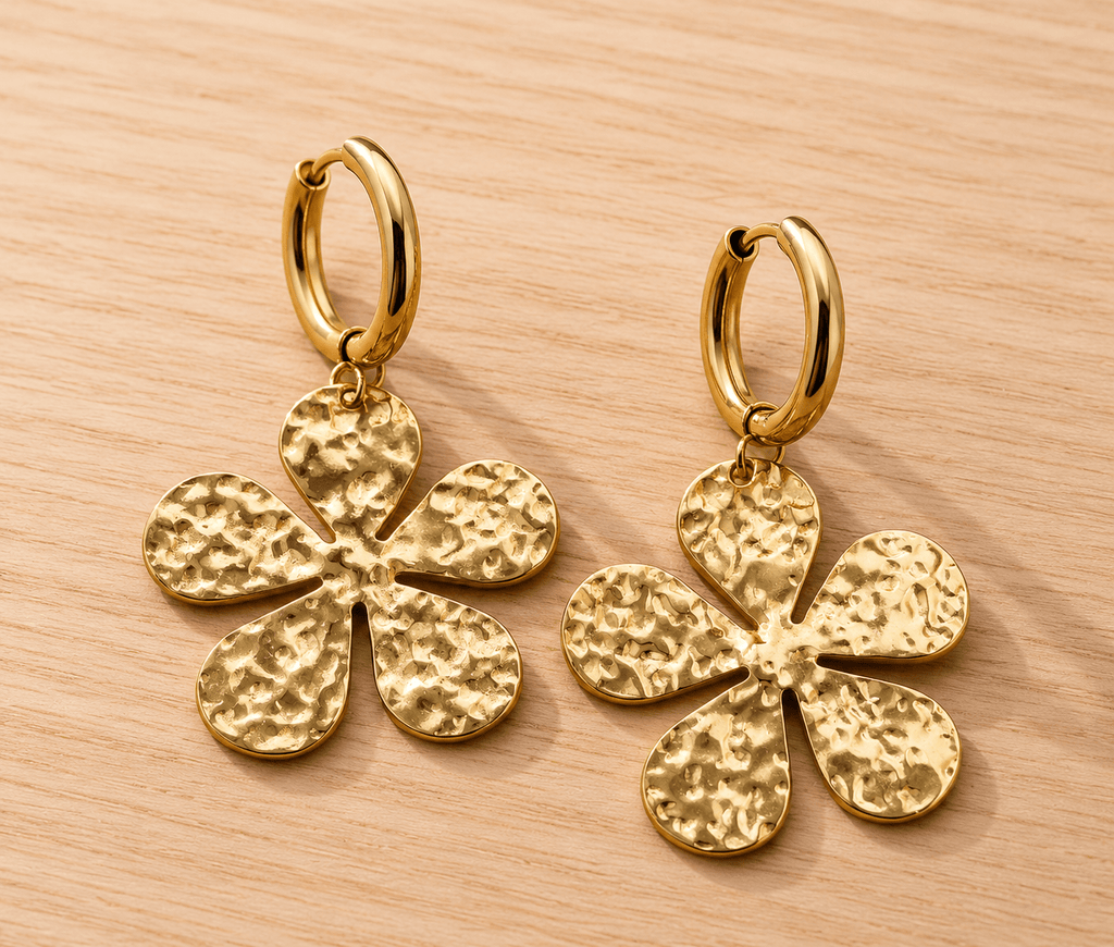 Paire de boucles d'oreilles dorées en acier inoxydable, créole lisse et pendentif fleur martelée texturée, fond bois