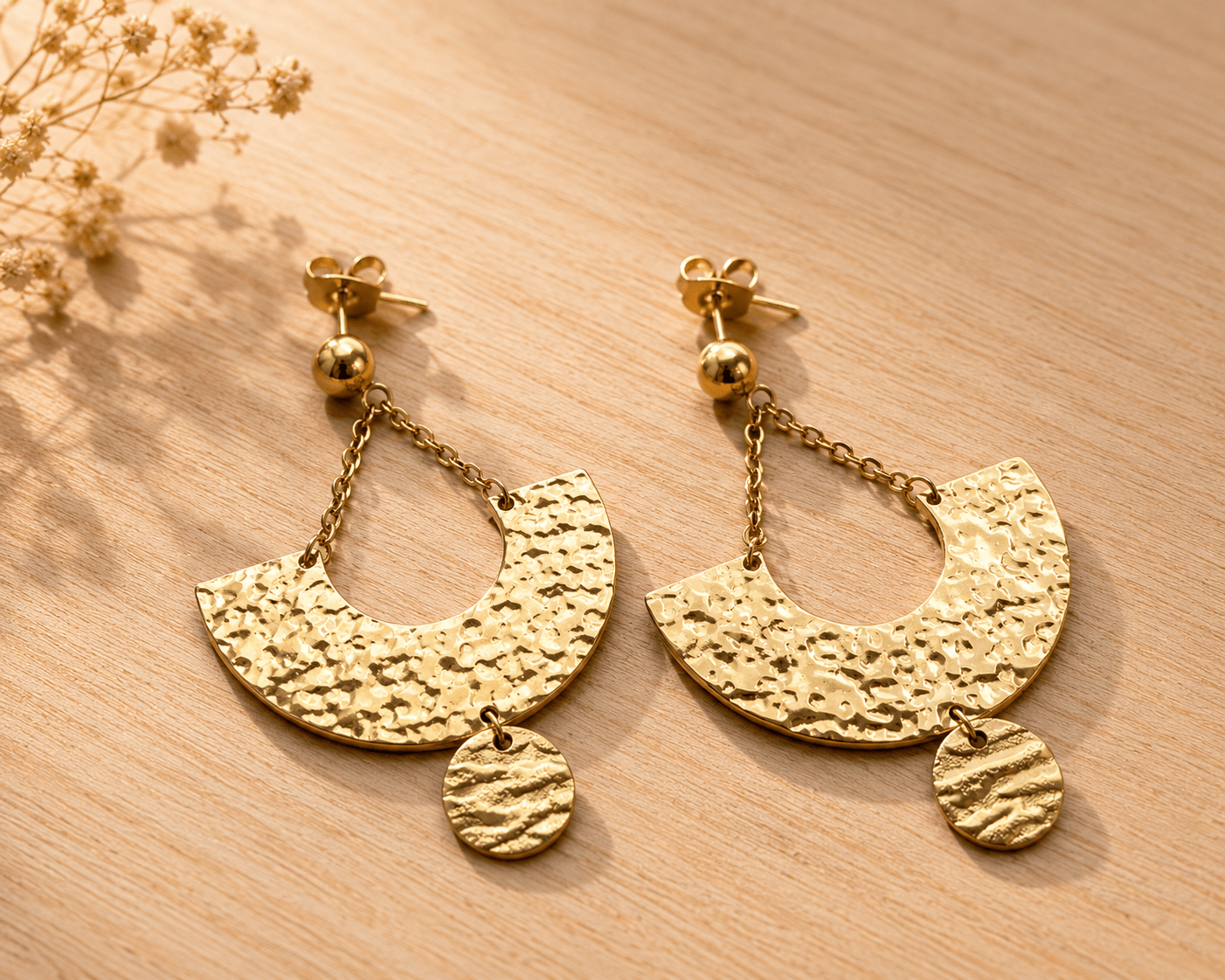 Paire de boucles d'oreilles dorées en acier inoxydable, forme demi-lune martelée suspendue par chaîne fine, avec médaillon rond texturé en pendant, puces billes dorées