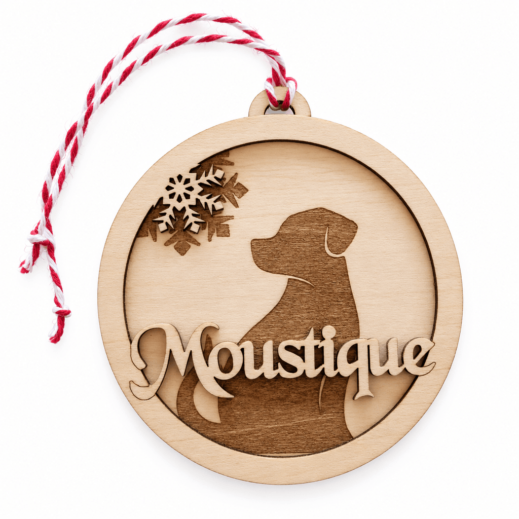 Boule de Noël ronde en bois multicouche avec silhouette de chien en relief et prénom gravé, sur fond blanc