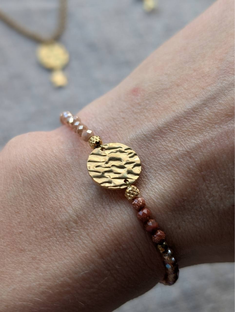 Rond texturé doré au centre du bracelet perles nude et terracotta, acier inoxydable doré