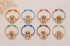 Collection de 8 bracelets enfant en bois gravé forme ronde, cordons colorés (orange, bleu, rose, gris, vert, bleu, marron, beige), motifs : chien, hippopotame, licorne, lion, chat, voiture, cerf, ourson