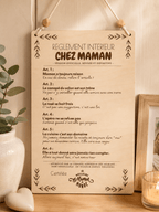 Plaque déco bois humoristique Chez Maman posée dans un intérieur cosy avec bougie et plante, cadeau original fête des mères