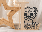 Lettre en bois personnalisée "L" avec lionceau et prénom "Lewis" gravé, date de naissance inscrite, entourée d'une étoile lumineuse et bougies décoratives