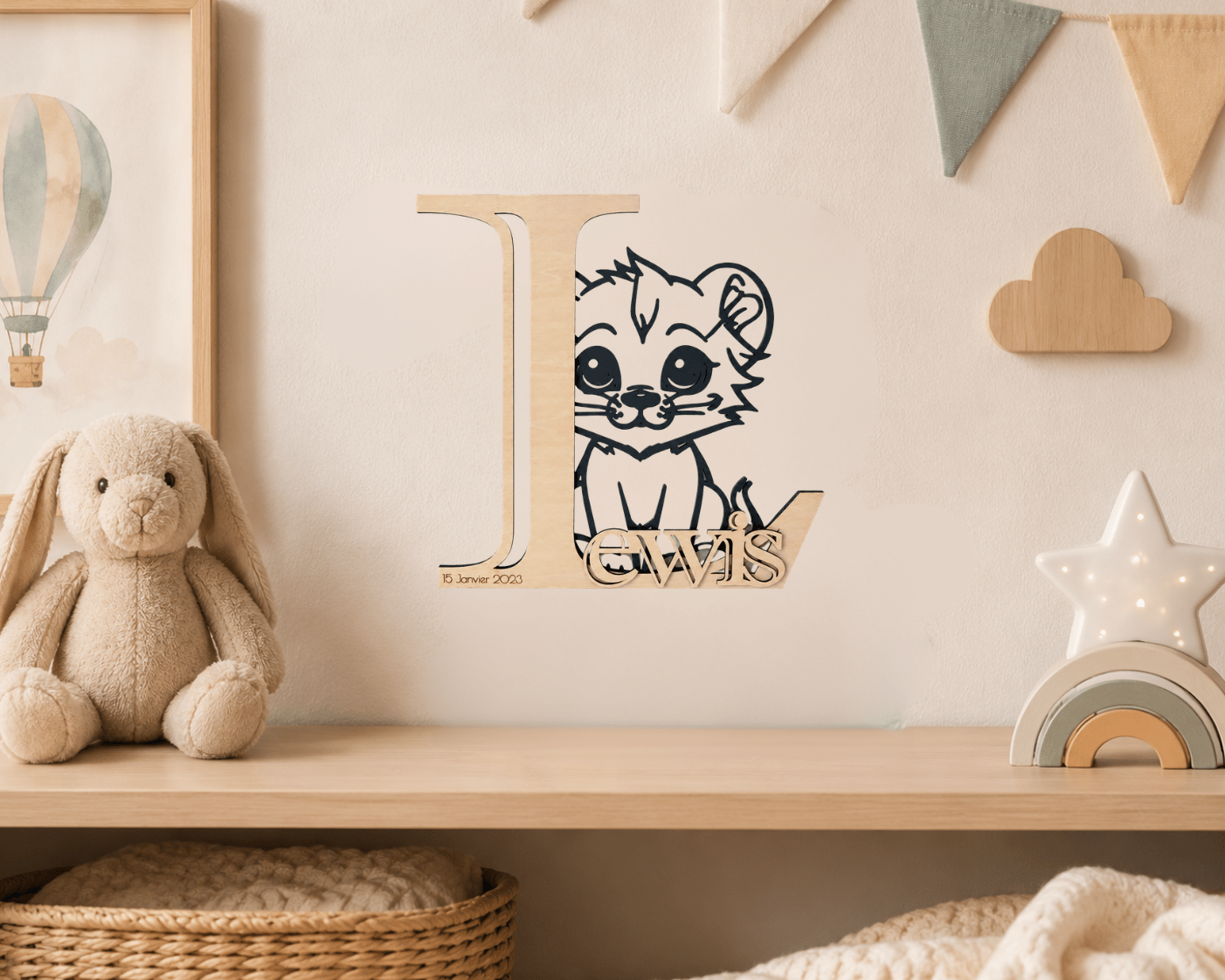 Lettre décorative personnalisée en bois "L" avec lionceau et prénom "Lewis" accrochée au mur d'une chambre bébé douce, avec guirlande fanions et étoile lumineuse