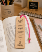 Marque-page en bois posé sur un livre ouvert – cadeau maîtresse personnalisé