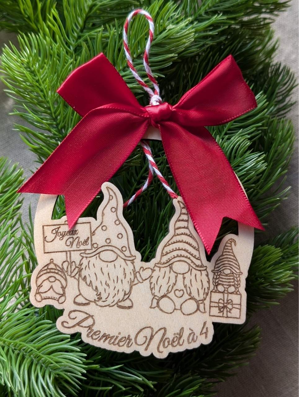 Boule de Noël en bois personnalisée gravée avec une famille de gnomes et nœud satin rouge inscrit premier noel  4