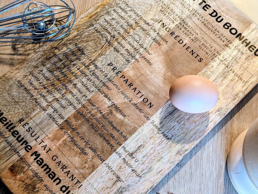 Gros plan de la gravure laser sur planche en bois de manguier, texte Préparation et Résultat Garanti gravé avec précision